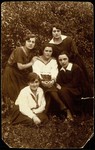 Dora Zlotnik Berkowitch sits in a garden with a group of friends from Olkenik.