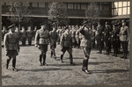 Nazi officials salute and walk in a courtyard at a seminar for Reich training and schooling in Erwitte.