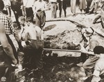 French civilians remove a charred corpse from the ruins of the church in Oradour.