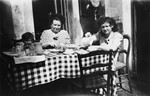 Hena Kohn and her younger cousin Marcel Shumiliver sit down to eat with their Belgian rescuer Alix Robert while in hiding.