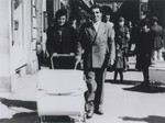 Gabriel and Theresia Reinhardt, a Sinti couple, push their twin children, Rolanda and Rita, along the Domstrasse in Wuerzburg under Nazi escort.