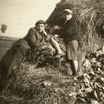 Two Jewish youth sit on a haystack in the Kolbuszowa ghetto.