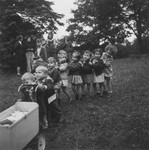 Young DP children march in line behind a toy baby carriage in one of "The Castles" children's homes established by Premysl Pitter and Olga Fierzova.