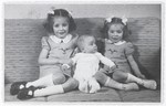 Three Jewish siblings pose on a sofa in their home in The Hague.