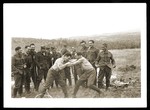 Two Jewish soldiers in the Slovak army wrestle while others look on.