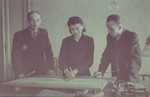 Three designers look over plans in the office of the furniture factory.