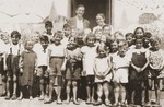 Friedel Reiter and August Bohny pose with a group of children in front of the Secours Suisse barracks in the Rivesaltes internment camp.