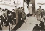 Children in the Rivesaltes transit camp line up outside the entrance to the Secours Suisse aux enfant barracks, where Friedel Reiter and Elsbeth Kasser are standing.