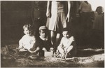 Three Jewish children in the Rivesaltes left orphaned after their parents were deported to Drancy sit on the straw strewn floor.
