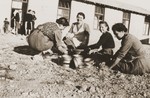 Secours Suisse aux enfants relief workers clean crockery with sand in the Rivesaltes internment camp.