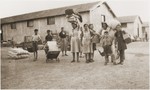 Women and children carry packages as they move to new quarters in the Rivesaltes internment camp.