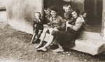 A group of [possibly Romani] children sit on a stoop of a building in the Rivesaltes internment camp.