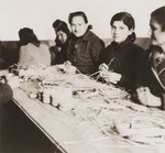 Female internees braid raffia in a workshop organized by the Secours Suisse aux Enfants.