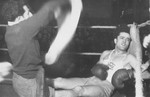 A boxer rests by the side of the ring during a match at the Zeilsheim displaced persons' camp.