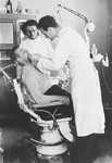 A dentist treats a camp resident in his office in the Zeilsheim displaced persons' camp.