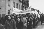 Men and women in the Zeilsheim displaced persons' camp carrying banners march in a demonstration for free immigration to Palestine.