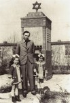 Henia Wisgardisky (left) stands with her father and cousin, Bluma Berk (right), in front of a memorial in the Zeilsheim displaced persons camp.