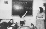 A young girl writes on the blackboard of a Hebrew class in the Zeilsheim displaced person's camp, "The Jews will immigrate to the Land of Israel".
