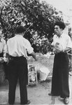 Two men engage in conversation in an outdoor market in the Zeilsheim displaced persons' camp.