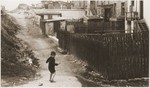 A Jewish boy walking in the back alley in the Bedzin ghetto.