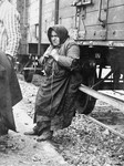 Babo Batren, an elderly Jewish woman from Tecso, leans against the deportation train in Auschwitz-Birkenau while waiting to be taken to the gas chambers.