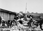 Prisoners in the Aufräumungskommando (order commandos) unload and sort the confiscated property of a transport of Jews from Subcarpathian Rus at a warehouse in Auschwitz-Birkenau.
