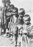 A group of barefoot, emaciated children stand outside in a row at the Jastrebarsko concentration camp.