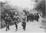 German soldiers and members of the Ustasa militia lead a group of Serbian villagers, who have been deported from their homes in the Kozara region, to a concentration camp in Croatia.
