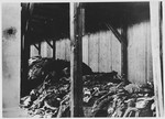 View of piles of clothing and other remains outside a barracks in the brickyard of Jasenovac III, known as KRPARA.