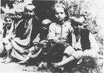 A group of barefoot, emaciated children sit outside at the Jastrebarsko concentration camp.