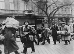 Hungarian Jews who were rescued from deportation by Raoul Wallenberg at the railroad station in the Józsefváros [Jozsefstadt] on November 28, 1944, walk along a street in Budapest on their way back to the "international ghetto".