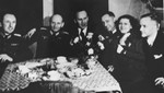 Oskar Schindler (center) enjoys himself at a dinner party in Krakow with German army officers.
