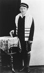 Bar Mitzvah portrait of Richard Bikakes wearing a tallit and holding a prayer book.