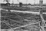 View of the barracks as seen from behind the barbed wire fence probably surrounding the Gurs concentration camp in France.