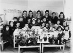 Young children and their dolls gather around a table to celebrate a birthday in the Wasseralfingen DP camp.