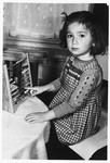 A young Jewish girl, Truusje Schoenfeld, plays with an abacus while living in hiding in The Netherlands.