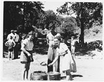 Henia Spielman (left) ladles out soup to two Jewish DP friends from the Gabersee DP camp during an outing in the woods.