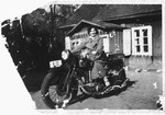 A young Jewish woman poses on a motorcycle outside her home in Kaunas, Lithuania.
