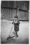 A young Jewish boy poses on his scooter near his home in Kaunas, Lithuania.