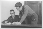 Interpreter Gerald Schwab (right) looks over a document with an unidentified commissioner at the IMT Nuremberg commission hearings investigating indicted Nazi organizations.