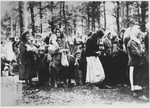 Yugoslav women and children are gathered in a wooded area during a deportation action.