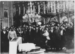 Serbian civilians who are being forced to convert to Catholicism by the Ustasa regime stand in front of a baptismal font in a church in Glina.
