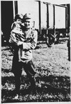 An unidentified soldier poses with a Serbian child in front of a railcar at the Pecana camp in the Sisak concentration camp for children.