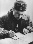 Ustasa Colonel Vjekoslav (Maks) Luburic signs a document.