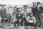 Jewish survivors pose next to a mass grave in Luboml.
