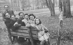 A group of Jewish displaced persons sits on a park bench in Munich.