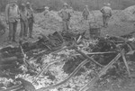 American soldiers on an inspection tour of the Ohrdruf concentration camp examine the remains of a pyre used to burn corpses.