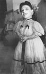 Portrait of a member of the Ovici family, a family of Jewish dwarf entertainers who survived Auschwitz, against a theatrical backdrop.