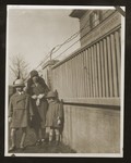 Mathilde Siegel poses by a fence with her two children Hans Peter and Maria Beate.