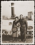 Mania and Gutman Grinewize pose in front of a boat on the Vistula river, during their visit to Warsaw.